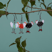 funny chicken earrings by Parada Jewelry are hung on a twig